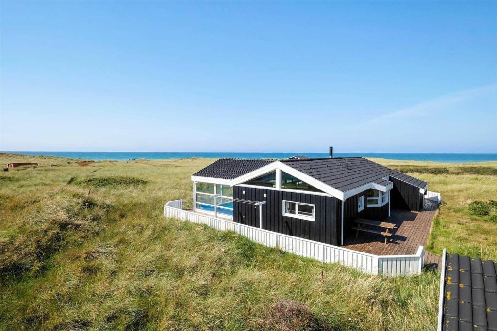 a black house in the middle of a field at LN1802-Hjorring-Bovlingbjergvej-4 in Hjørring