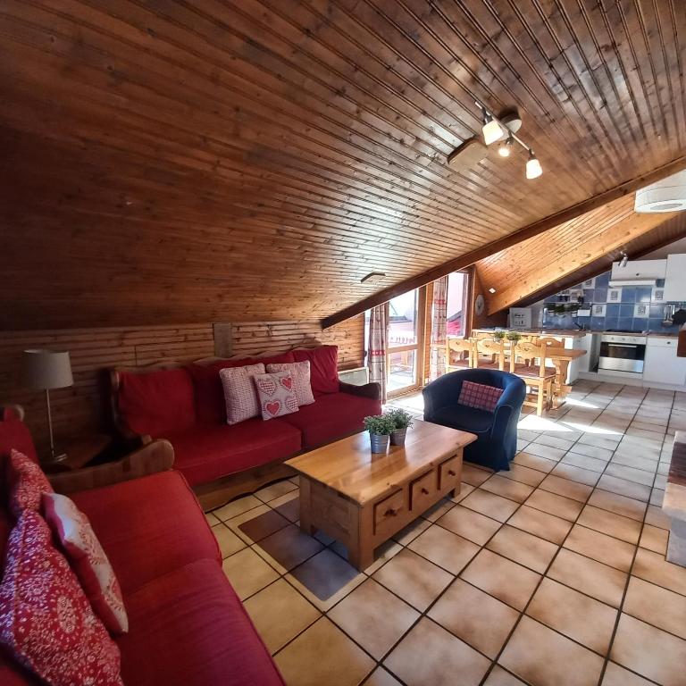 Hotel 13 Lou Veno, a living room with red couches and a table at 13 Lou Veno in Les Deux Alpes