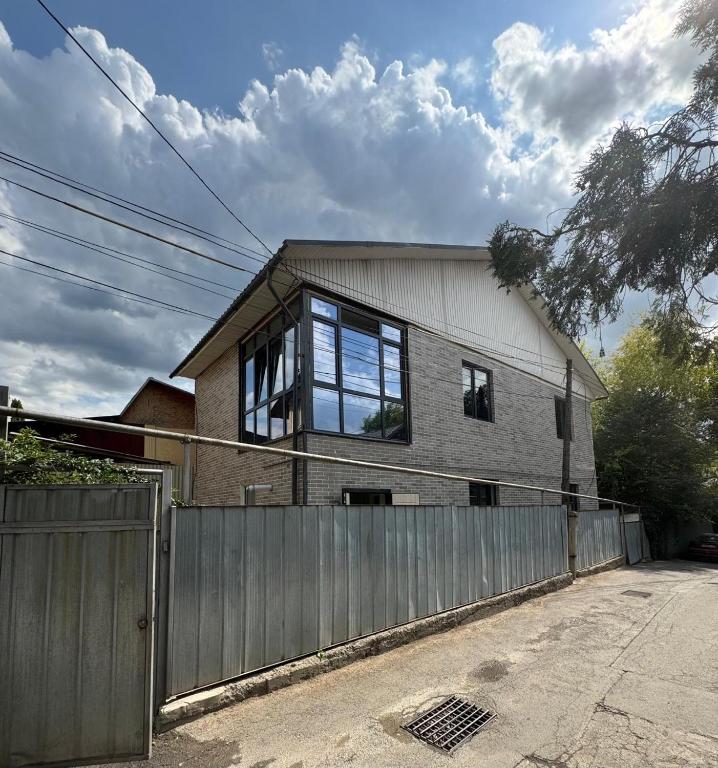 a house with a fence in front of it at Hostel lux Esenberlina in Almaty