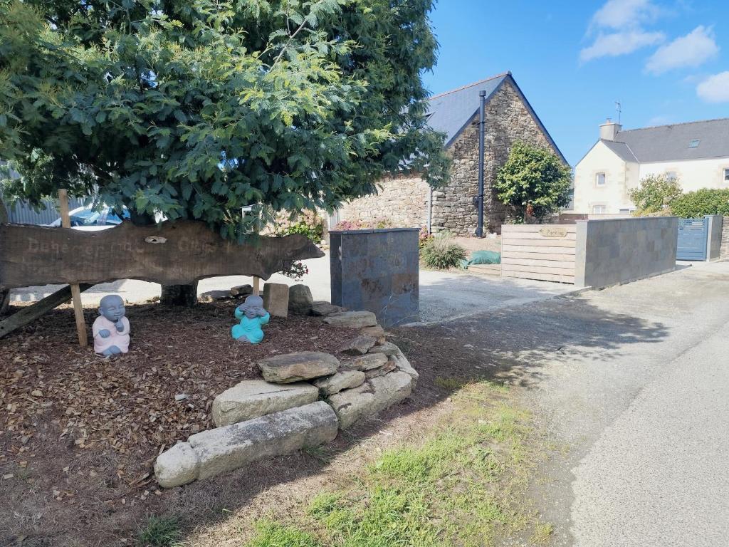 deux ours en peluche assis dans un jardin sous un arbre dans l'établissement Les gîtes de L'hermine, à Plouigneau