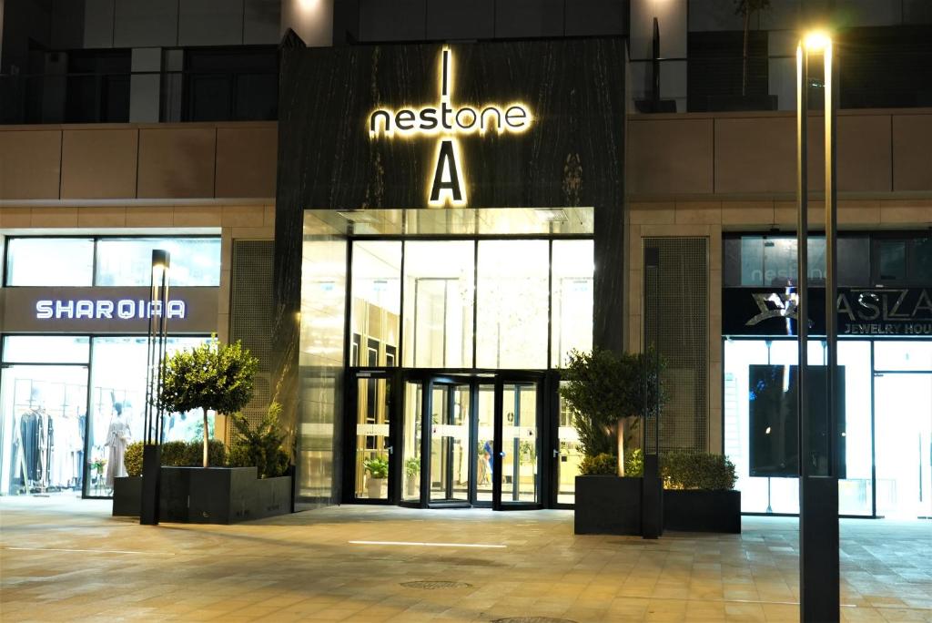 un magasin avec une enseigne sur la façade d'un bâtiment dans l'établissement Nest One, à Tachkent