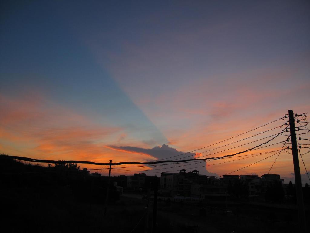 a sunset with power lines in front of a city at Sea Front Homestay in Magong