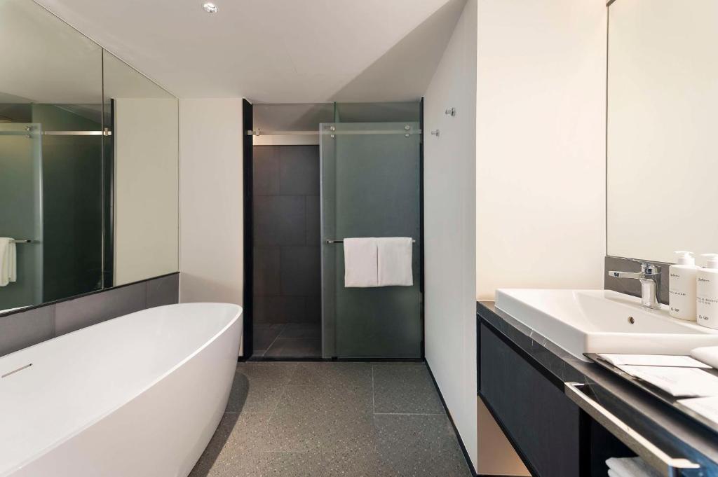 A contemporary bathroom with a freestanding tub, separate glass-enclosed shower and single vanity.