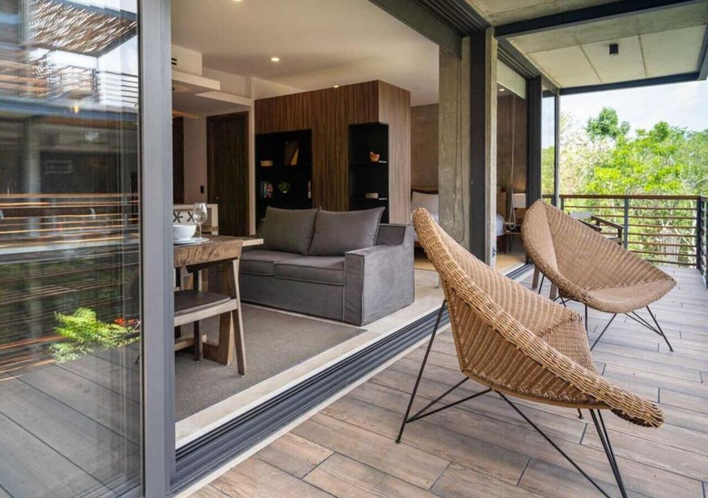 a living room with a couch and chairs on a patio at Ideal Location with Cenote Pools Gym Restaurant in Tulum