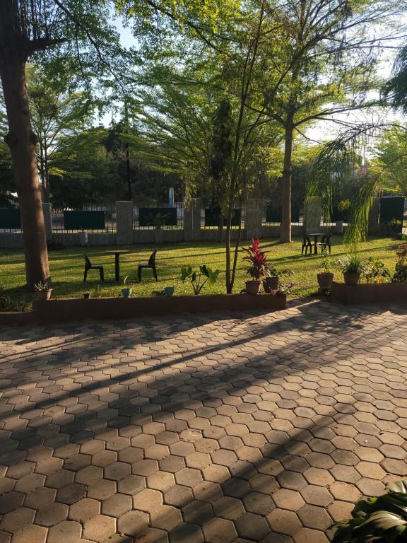 a park with benches and trees in the shade at Guestmate Inn in Livingstone