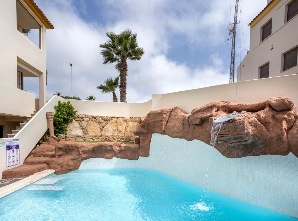 ein Schwimmbad vor einem Gebäude in der Unterkunft Luxe Appartement Costa Blanca Altamira Las Ramblas in Orihuela