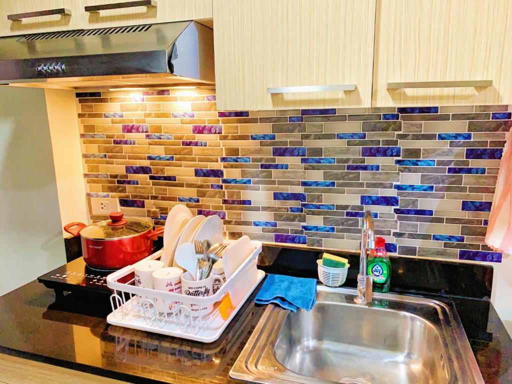 eine Küchentheke mit Spüle und eine Arbeitsplatte mit Spüle in der Unterkunft Cozynest Condotel Baguio unit 2 in Baguio City