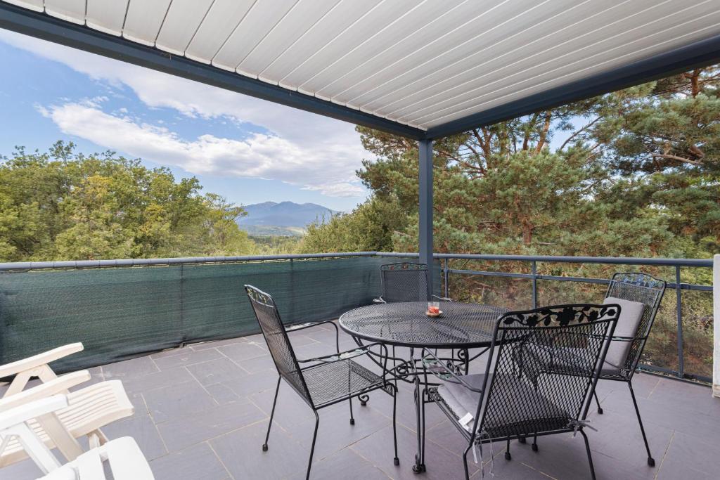 Un patio con una mesa y sillas en un balcón. en Gîte F2, Dans Un Coin De Paradis, en Céret