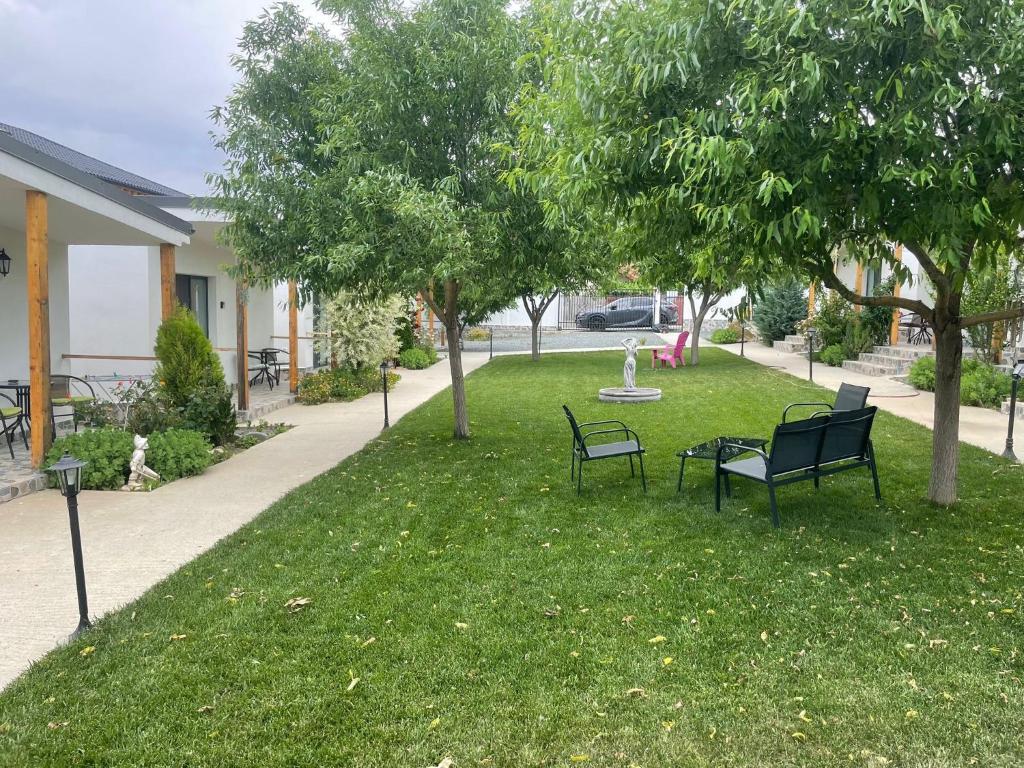 a park with two chairs and a fountain in the grass at Vara la Corbu in Corbu