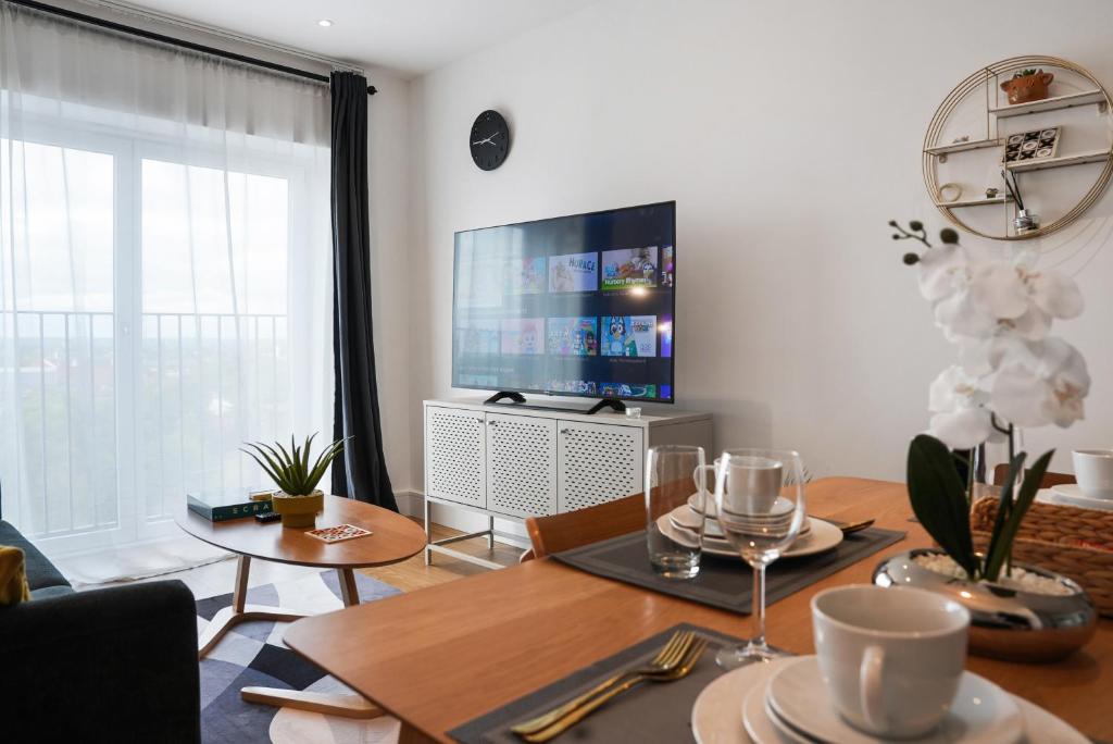 a living room with a table and a large television at Onyx place in Birmingham
