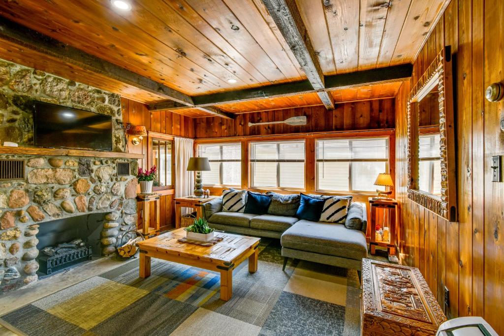 PrudenvilleにあるWalk to Houghton Lake Cabin with Fire Pit!のソファと暖炉のあるリビングルーム