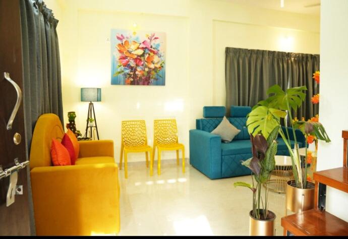 a living room with a blue couch and chairs at Tej Villa, 3 Bhk villa at pushpam sanskruti,Karjat in Dhamni