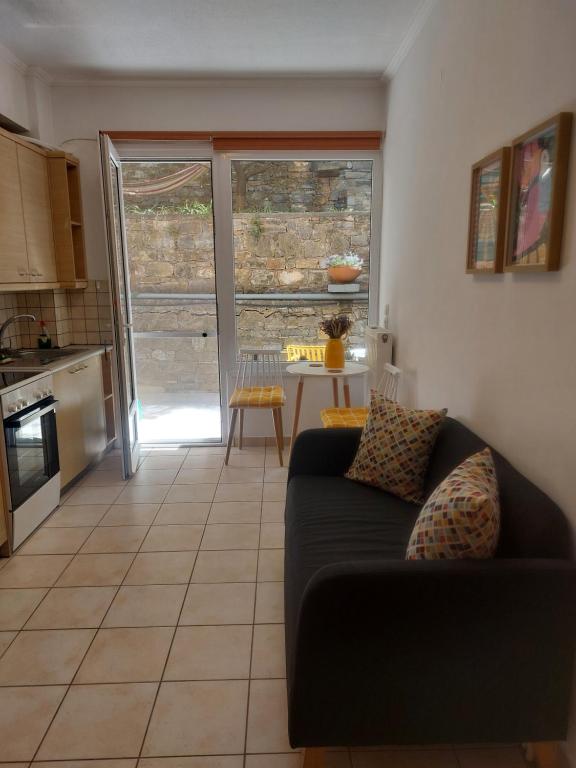 a living room with a black couch and a kitchen at Samos Cozy Apartment II in Samos