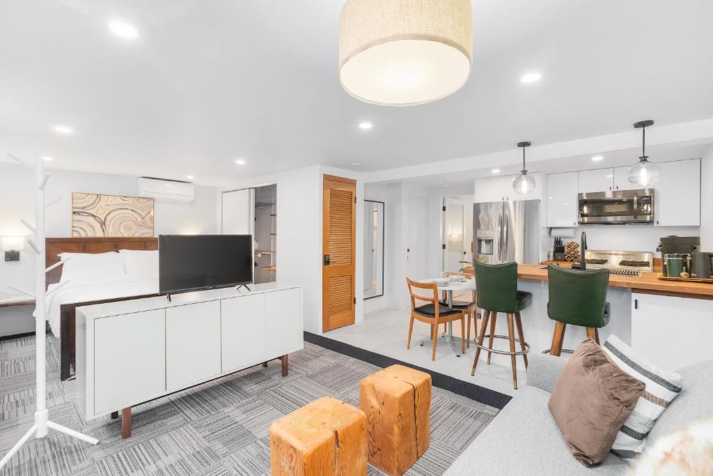 a kitchen and living room with white cabinets and green chairs at Sunnyside Studio on Green Lake in Seattle