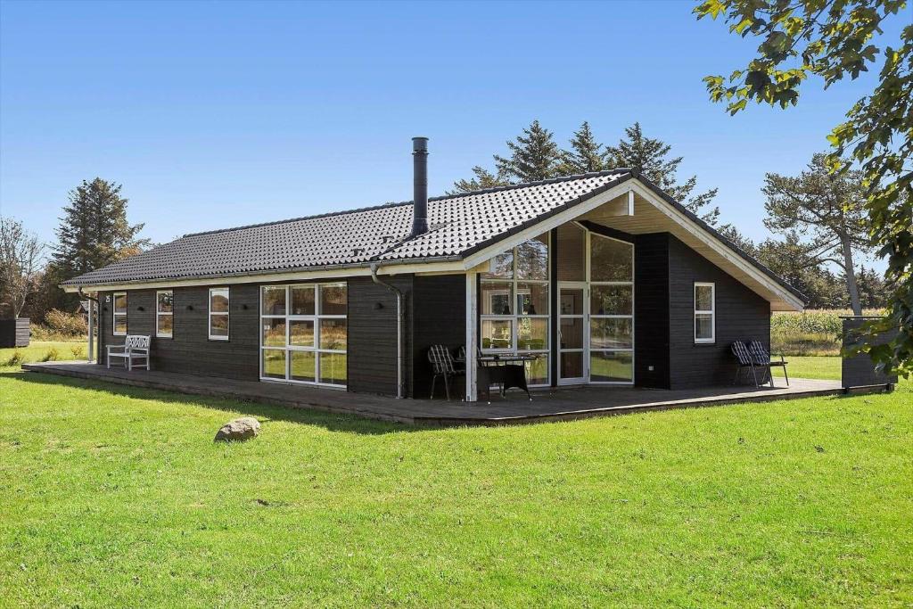a small black house with a large window at LN1931-Hjorring-Norre-Knoldevej-25 in Hjørring