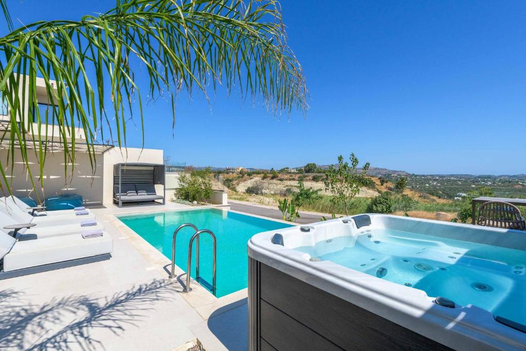 a swimming pool with a hot tub on a patio at Villa Trapezia Diamond in Kolymbia