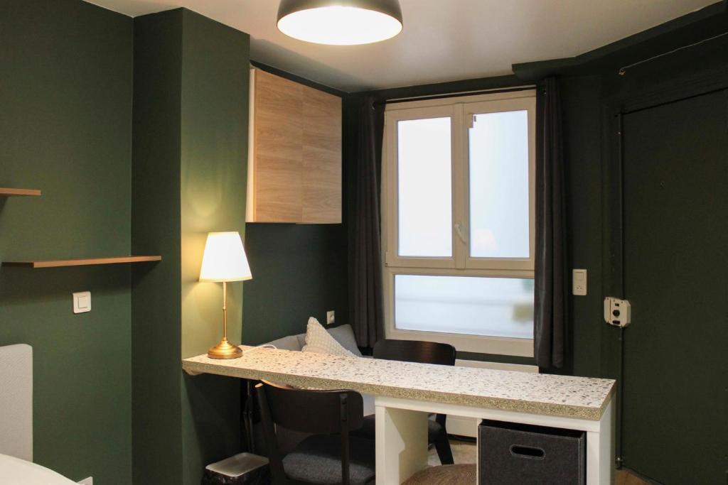 a green room with a desk and a window at Studio 2 steps from the Musée Grévin in Paris