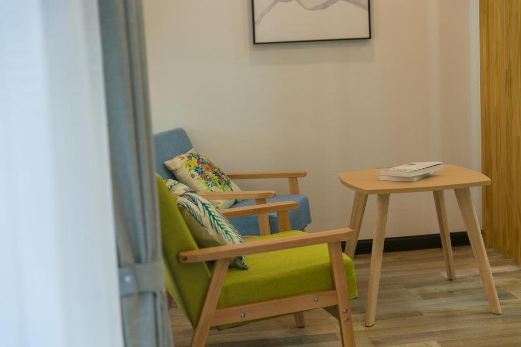 a chair and a side table in a room at Zhuzhi Light Luxury B&B in Lijiang