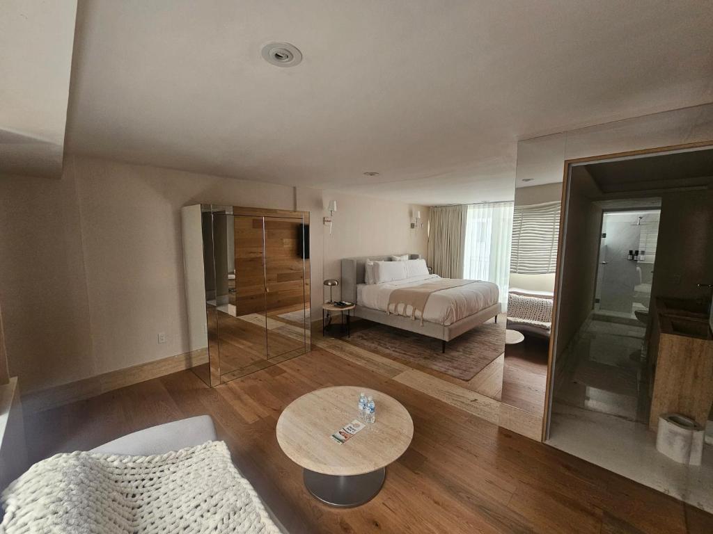 een woonkamer met een bed en een tafel bij Residence L Heritage Tennyson in Mexico-Stad