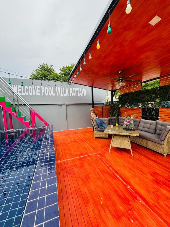 a living room with a wooden floor and a table at Kate Pool Villa Jomtien Pattaya in Pattaya