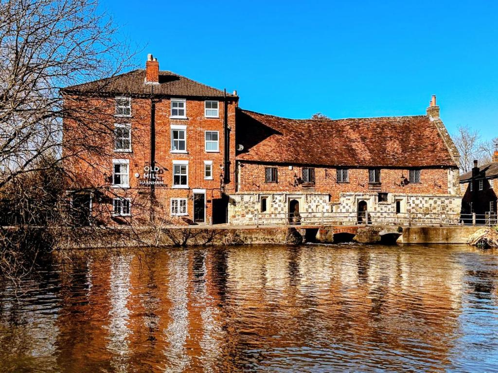 un gran edificio de ladrillo junto a un río en Old Mill hotel, en Salisbury