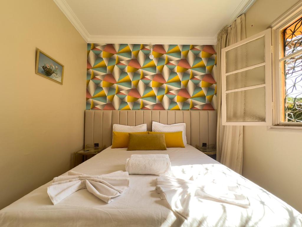 Un dormitorio con una cama con un cuadro en la pared. en Appartement lumineux avec Jardin à la palmeraie, en Marrakech