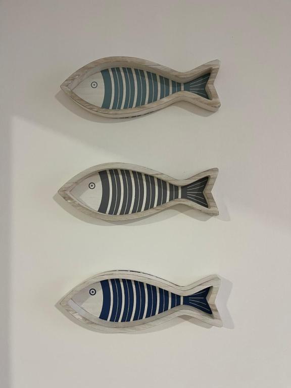 a group of three wooden fish on a table at Casa A'Bareis in Polignano a Mare
