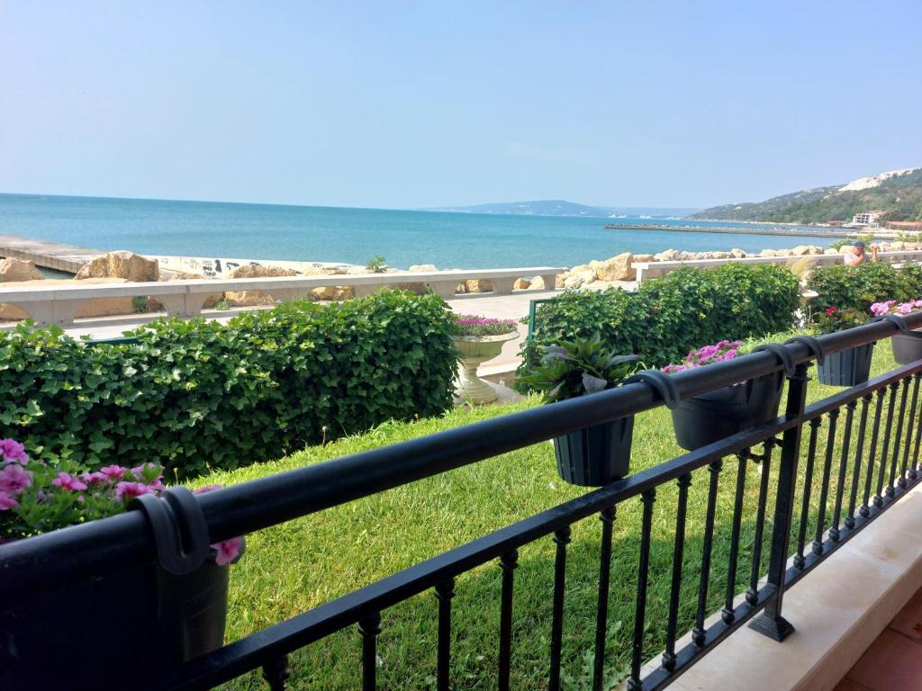 a balcony with a view of the ocean and flowers at Apartment Caricia complex Carpe Diem Balchik - sea view & free parking in Balchik