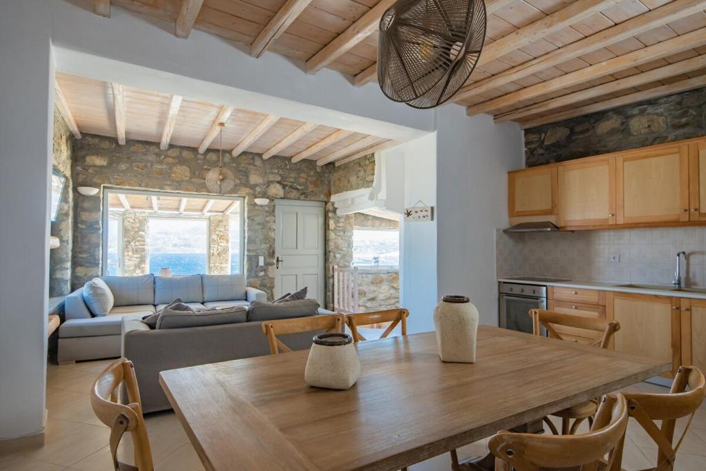 a kitchen and living room with a table and a couch at Natural Stone Villa II in Mýkonos City