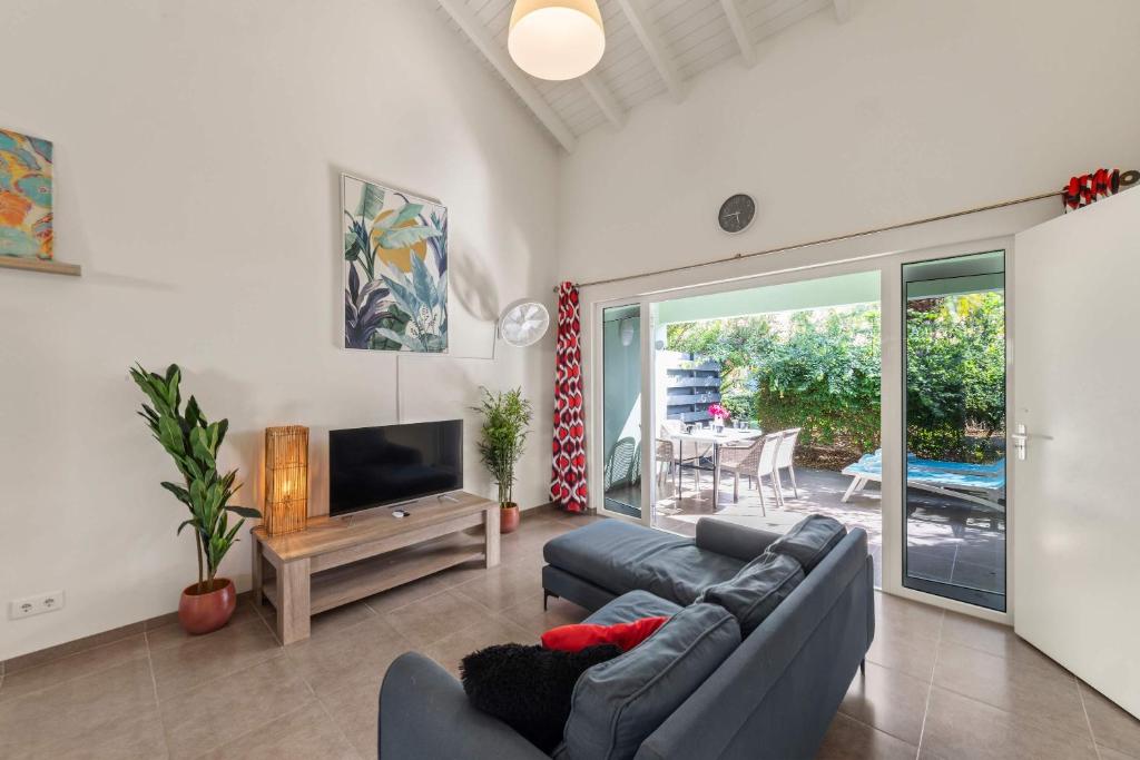 a living room with a couch and a television at Casa Verde - Blije Rust I in Sint Michiel