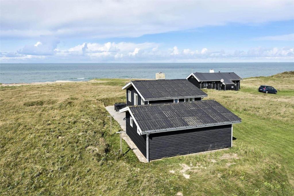 a house with solar panels on it next to the ocean at LN76158-Hjorring-Bredningen-18 in Hjørring