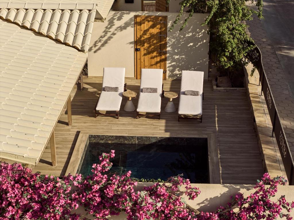 a group of chairs sitting on a patio with flowers at Ilision - Contemporary Living Residences in Argassi