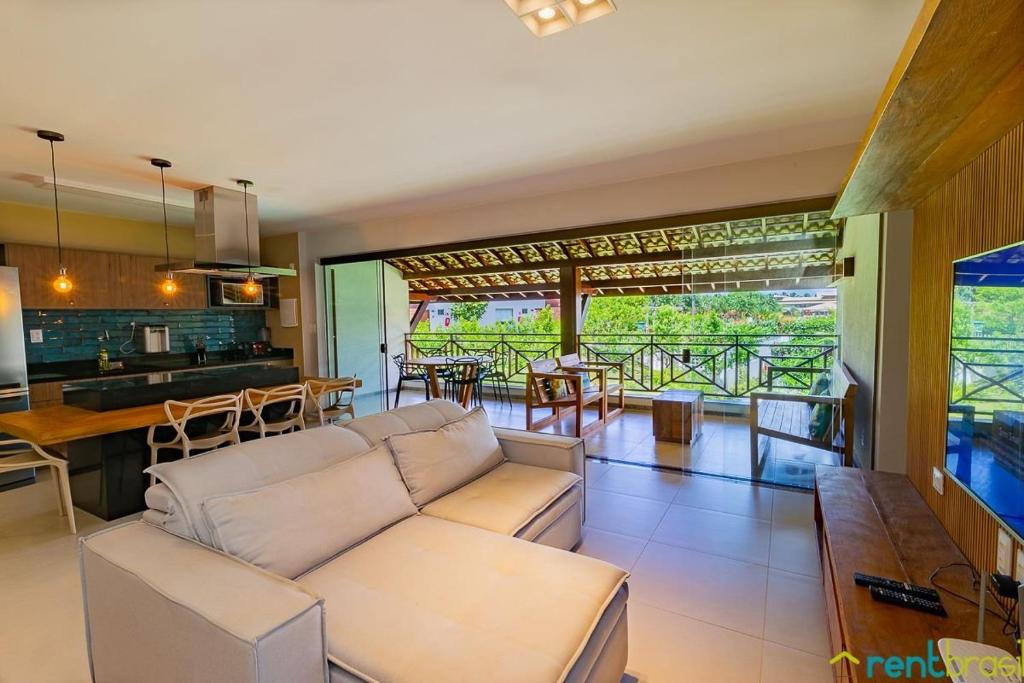 a living room with a white couch and a kitchen at Ykutiba Imbassaí - Apartamento Superior - I104 in Imbassai