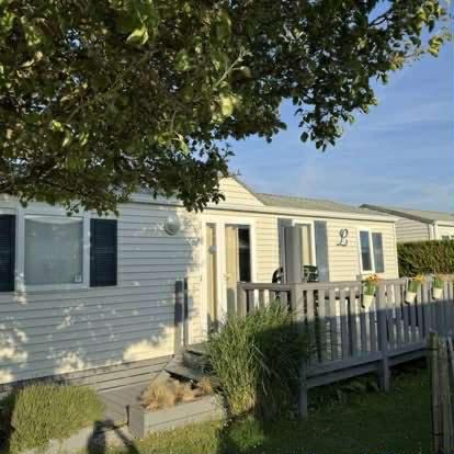 a white house with a fence in front of it at Claire's Cottage in Knokke-Heist