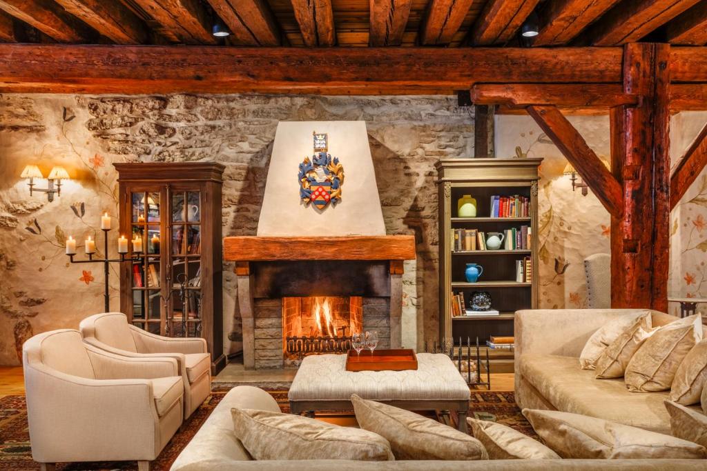 a living room with a fireplace and a stone wall at Schlössle Hotel - The Leading Hotels of the World in Tallinn