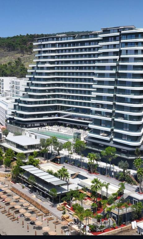 a large building with a parking lot in front of it at Mias Apartment - Ilyonis Residence in Shëngjin