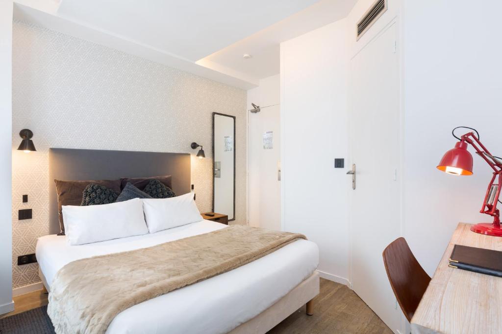 
a hotel room with a bed and a lamp at Hotel OHM by Happyculture in Paris
