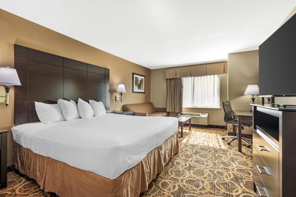 a hotel room with a large bed and a desk at Best Western Northwest Inn in Dallas