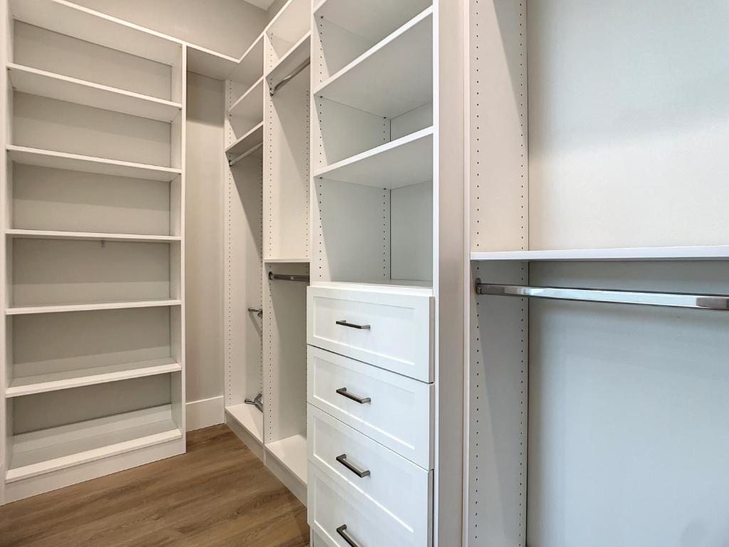 a walk in closet with white shelves and drawers at Lala at the Beach 512 in Chicken Island