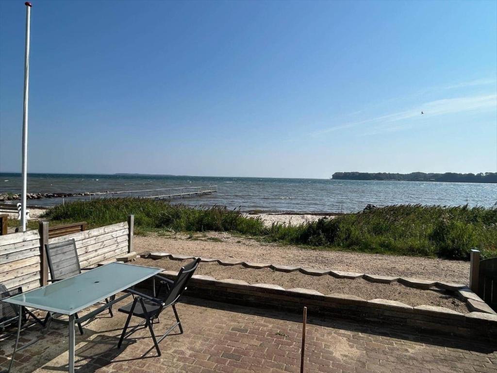 un tavolo da picnic e sedie sulla spiaggia di SJ269-Hejls-Ved-Kysten-1 a Hejls