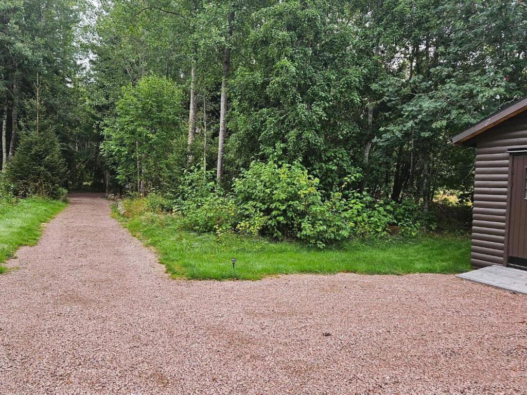 a gravel road next to a building and trees at 4 star holiday home in BY KYRKBY 