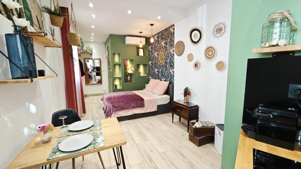 Una habitación con una cama y una mesa con un comedor. en Studio de charme climatisé Gare Riquier, en Niza