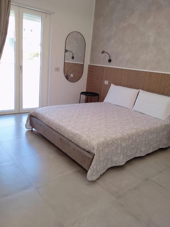 a bedroom with a large bed and a mirror at Cabrí rooms in Vieste