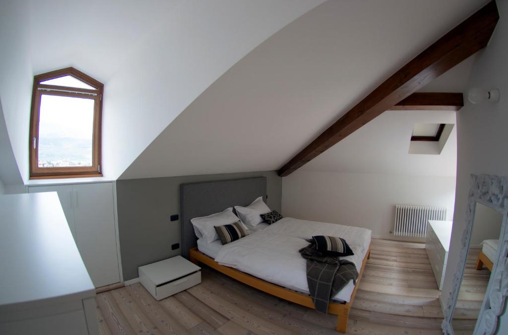 リーヴァ・デル・ガルダにあるAppartamento i Sentieri 23のベッドルーム1室(窓のある屋根裏部屋のベッド1台付)
