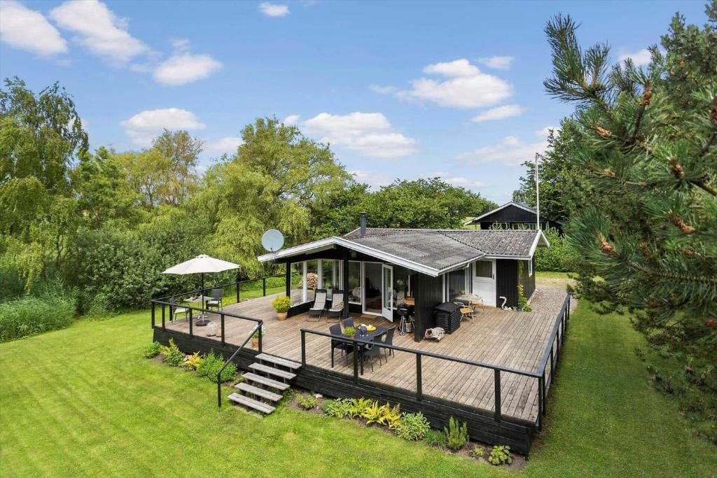 a house with a wooden deck in a field at LL252-Humble-Laxtonvej-36 in Humble