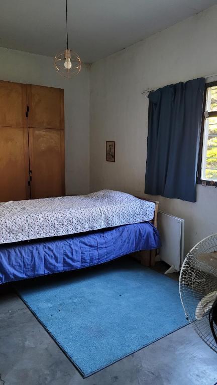 Un dormitorio con una cama y una alfombra azul. en Casadearte, en Arana