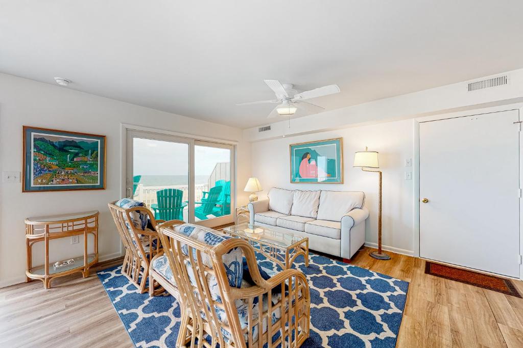 Una sala de estar con un sofá, una mesa y sillas. en Town of Bethany Beach -- 96C Second St, en Bethany Beach