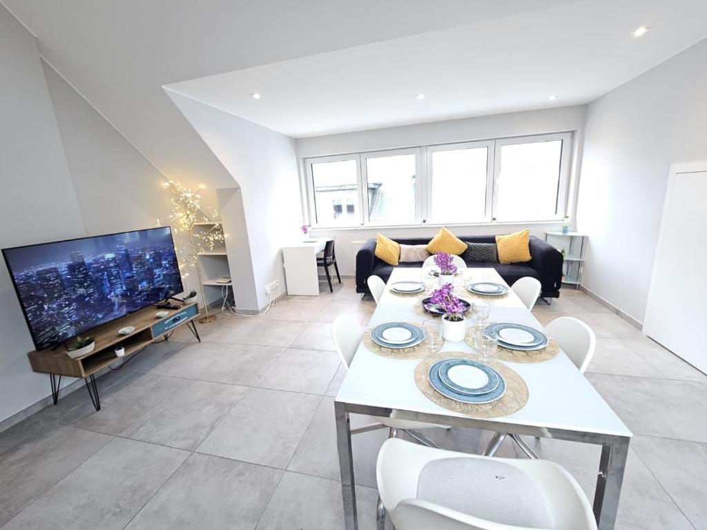 a living room with a table and a tv at Homey 2BR Flat with parking in Luxembourg