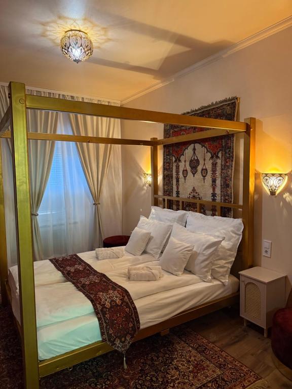 - une chambre avec un lit à baldaquin et des oreillers blancs dans l'établissement HAREM romantic apartment, à Eger