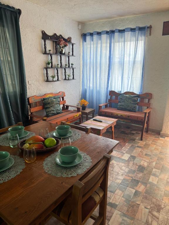 a living room with a wooden table with bowls of fruit on it at Casa del sol rustic stay in La Paz
